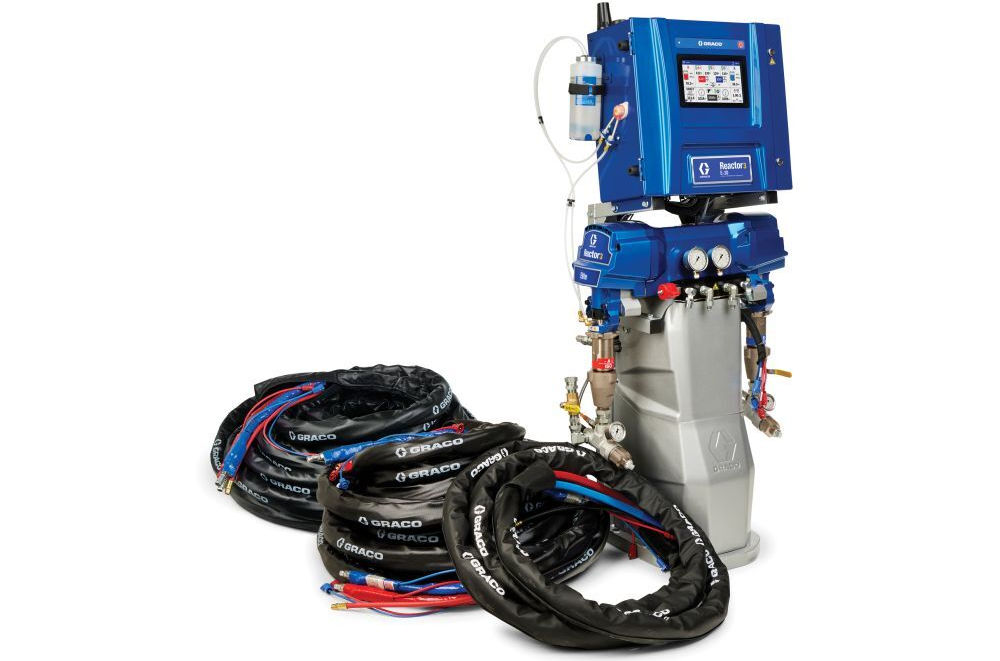 Industrial painter wearing protective gear applying spray coating with a high-pressure spray gun